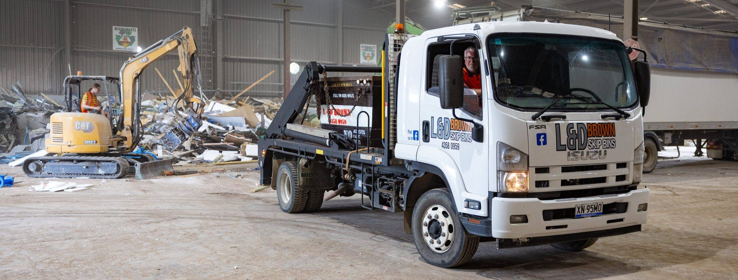 Employee Loading Waste Bin For Efficient Disposal in Central Coast
