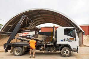 Worker Lifting a Bin for Waste Management Services in Central Coast